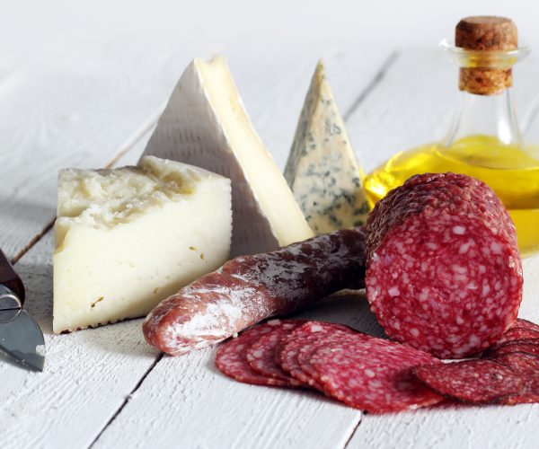 Salami and cheese on wooden table
