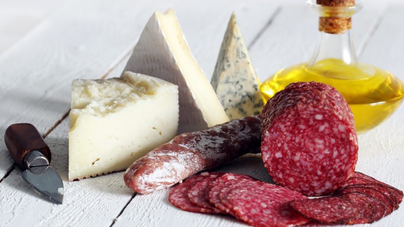 Salami and cheese on wooden table